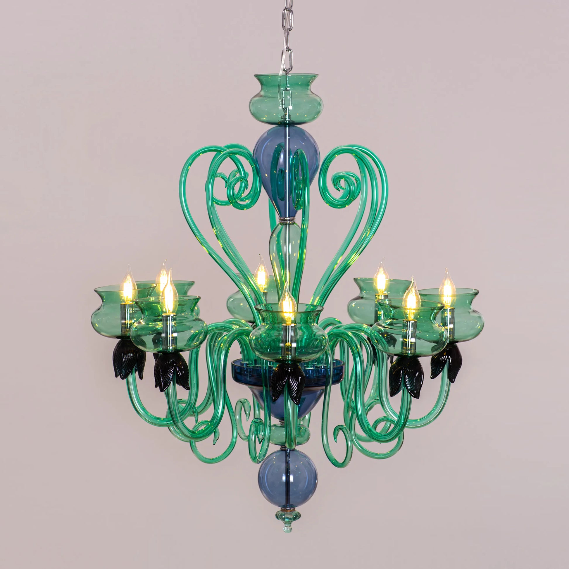 Kind To The Mind large green and blue clear glass chandelier illuminating a peaceful yoga studio