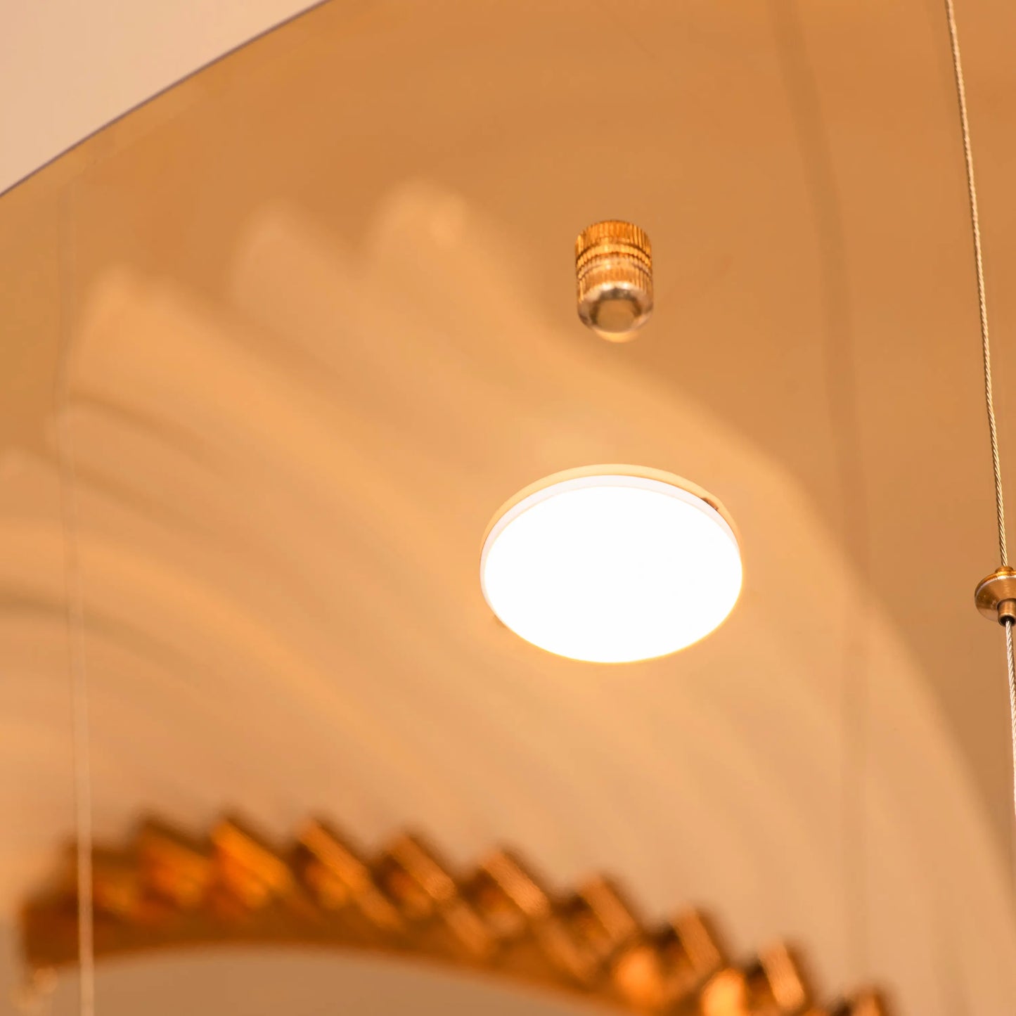 Large gold and white Chefs Kiss chandelier with frosted glass, hanging in a spacious living room