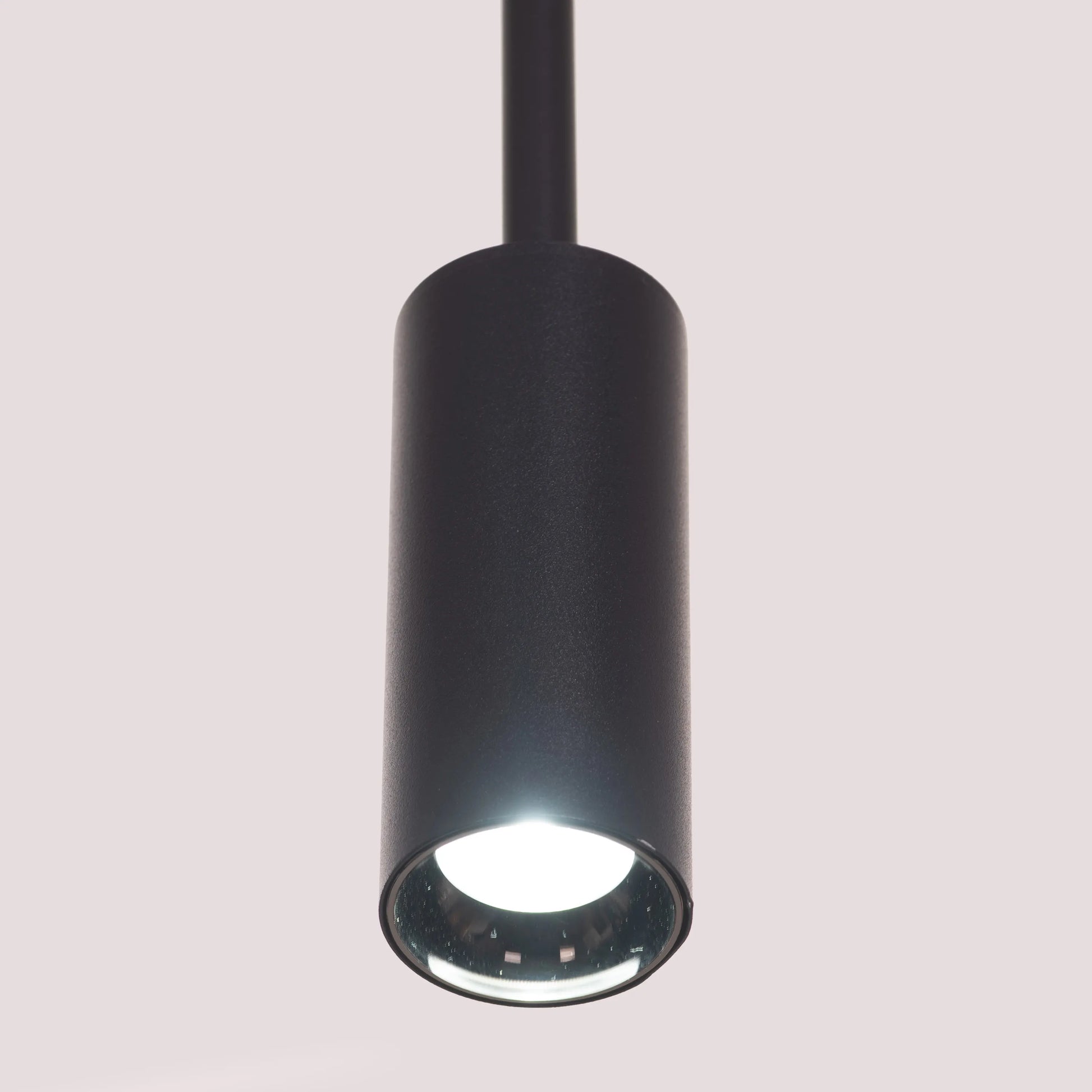 Ring On It Black Chandelier suspended in a modern living room, emitting a warm white glow
