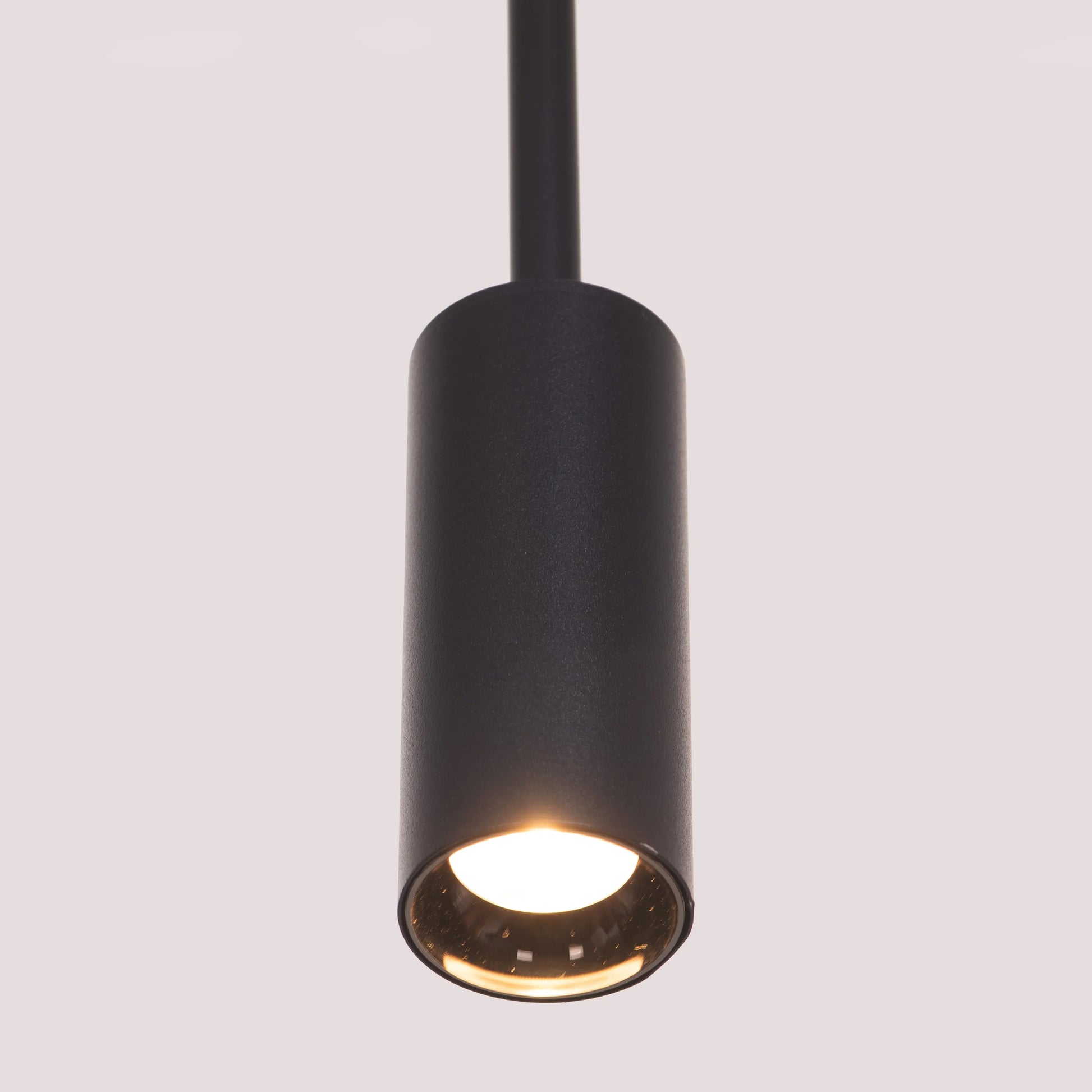 Ring On It Black Chandelier suspended in a modern living room, emitting a warm white glow