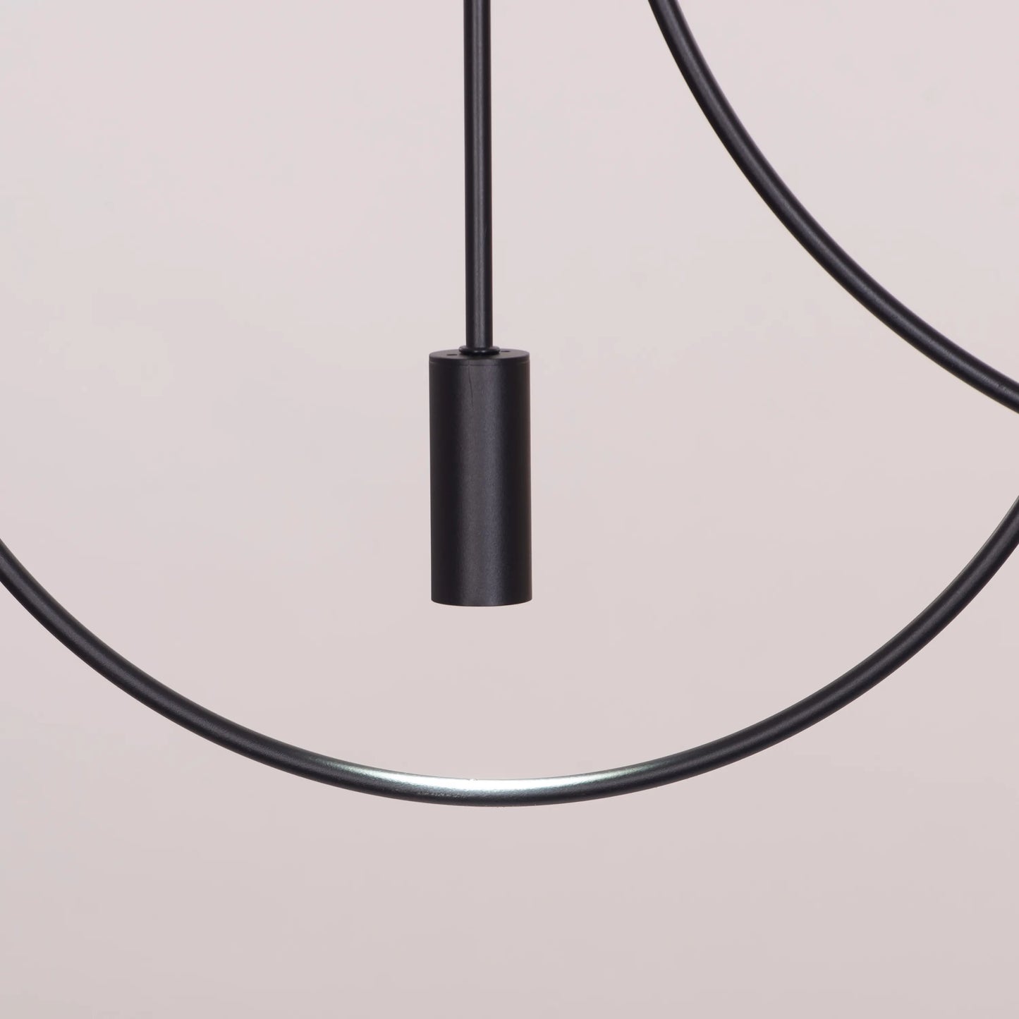 Ring On It Black Chandelier suspended in a modern living room, emitting a warm white glow