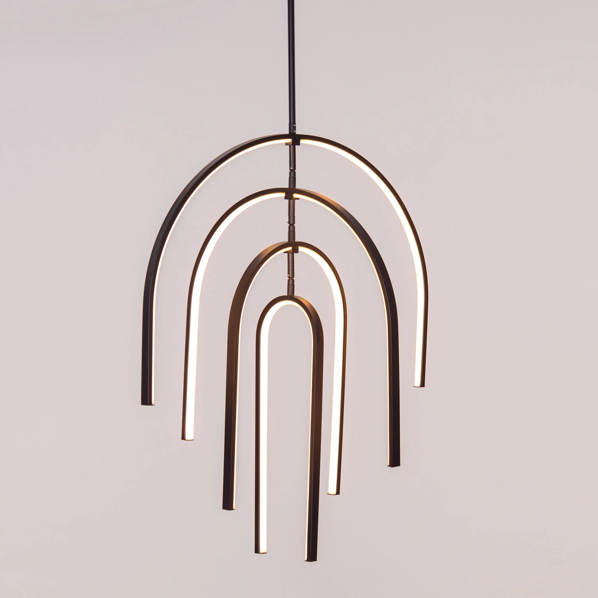 Heatwave Black Chandelier illuminating a room with vibrant amber light, showcasing its unique wave-inspired design