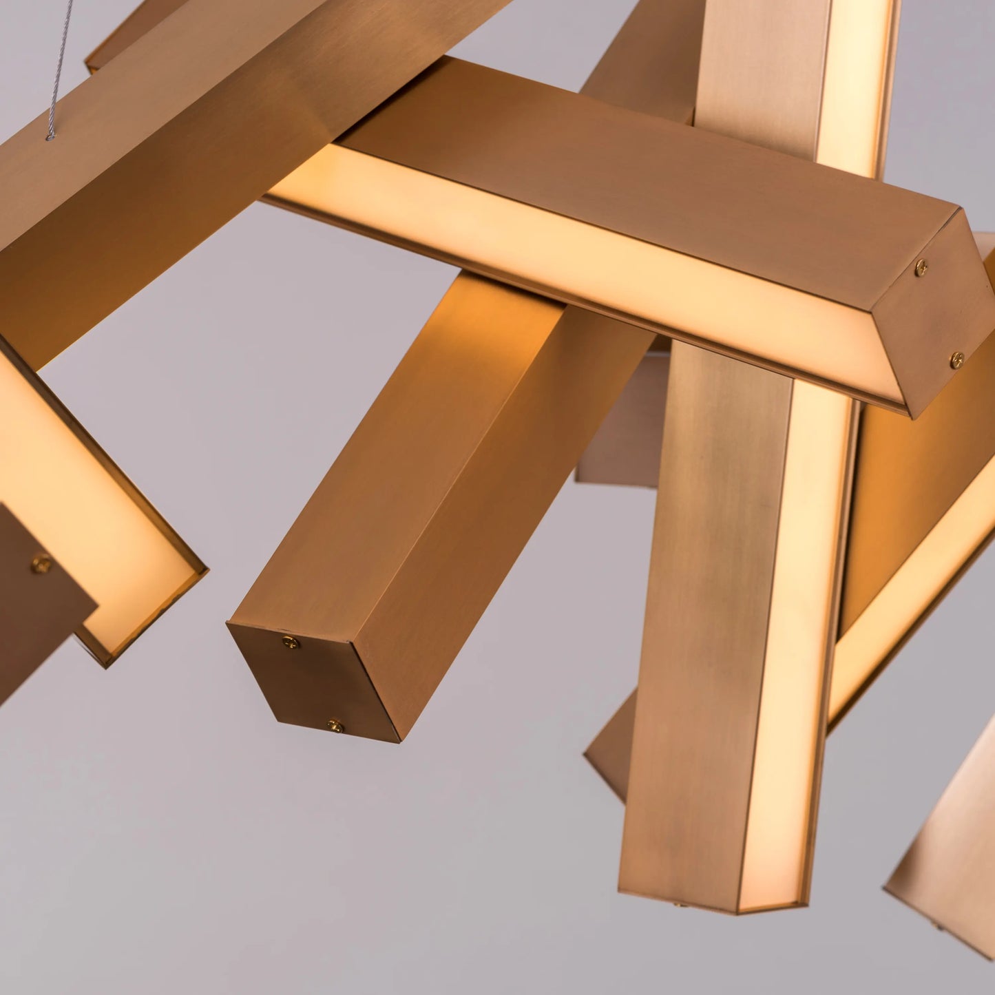 Large "Glow Miles" gold chandelier with multiple LED light sources, dramatically illuminated in a spacious, modern room.