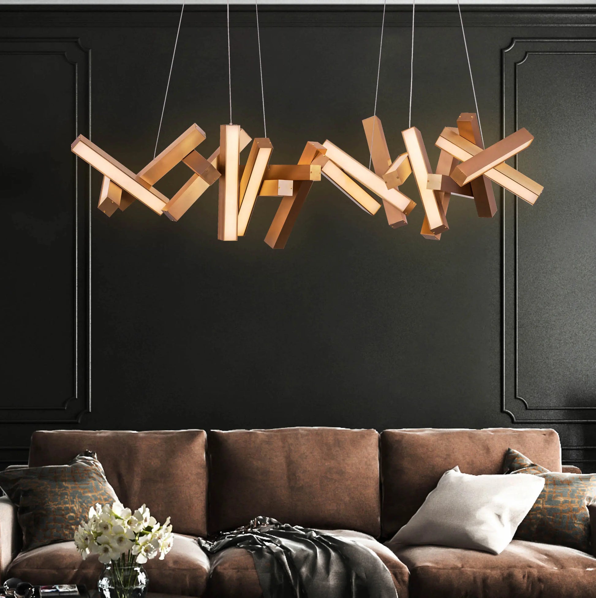 Large "Glow Miles" gold chandelier with multiple LED light sources, dramatically illuminated in a spacious, modern room.