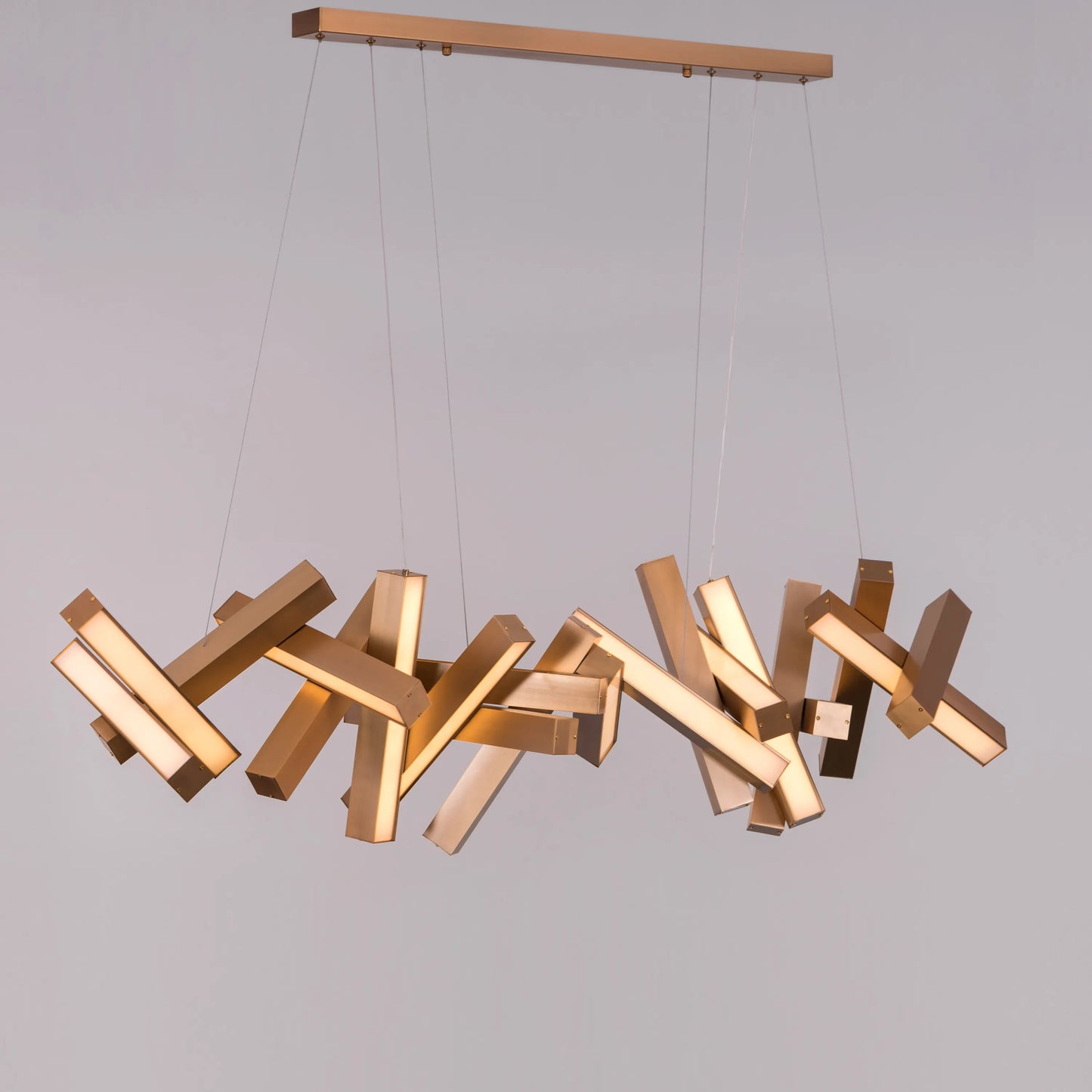 Large "Glow Miles" gold chandelier with multiple LED light sources, dramatically illuminated in a spacious, modern room.