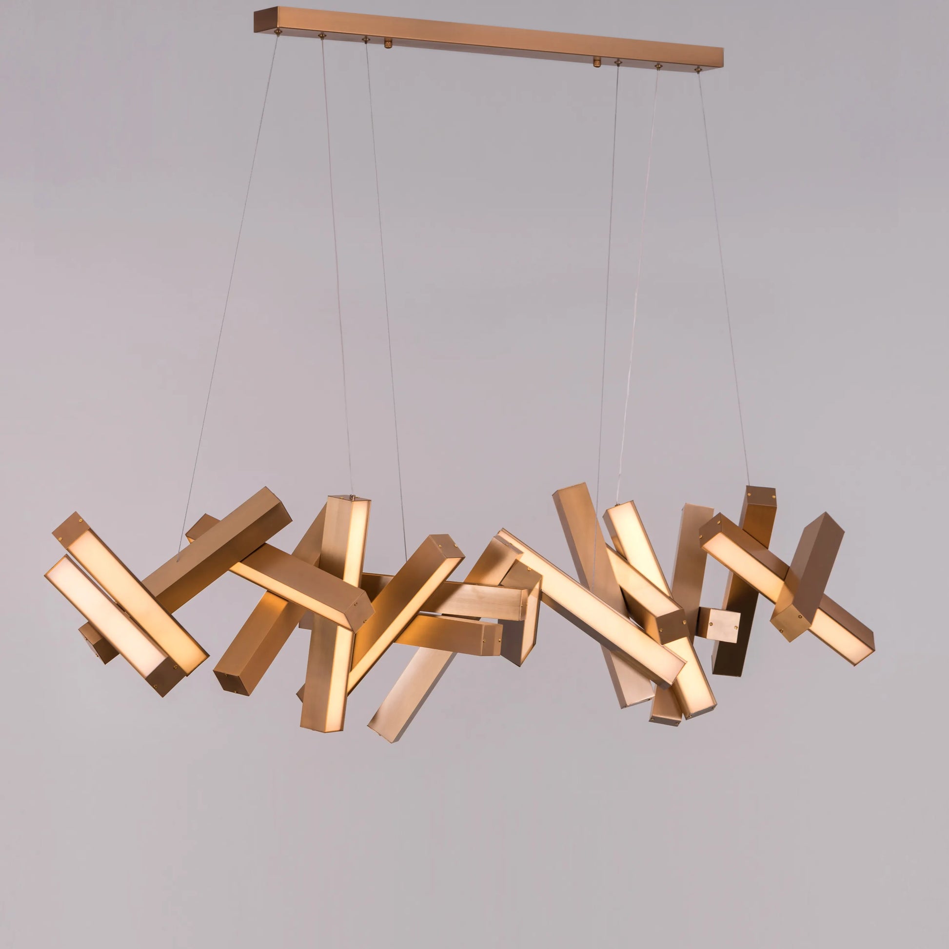 Large "Glow Miles" gold chandelier with multiple LED light sources, dramatically illuminated in a spacious, modern room.