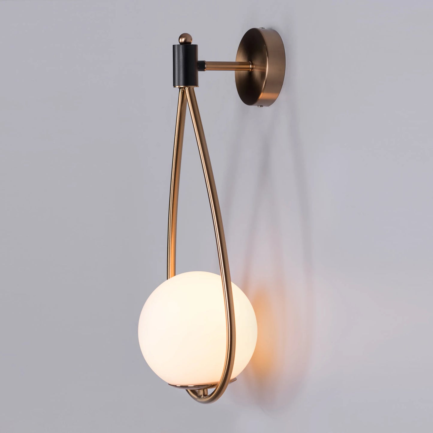 Sleek glass and metal wall light adding warmth to a minimalist living room.