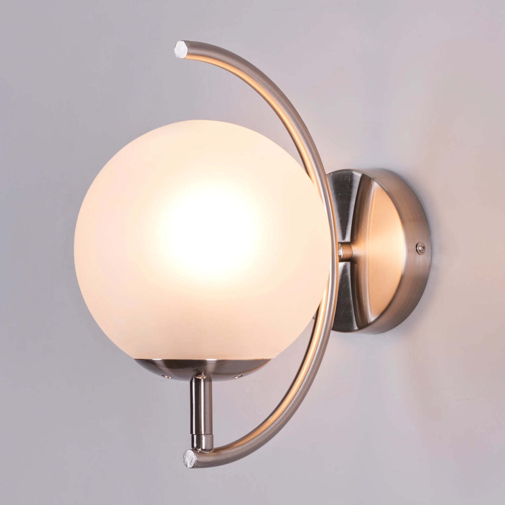 Show Me Love wall light casting a warm glow in a minimalist bedroom.