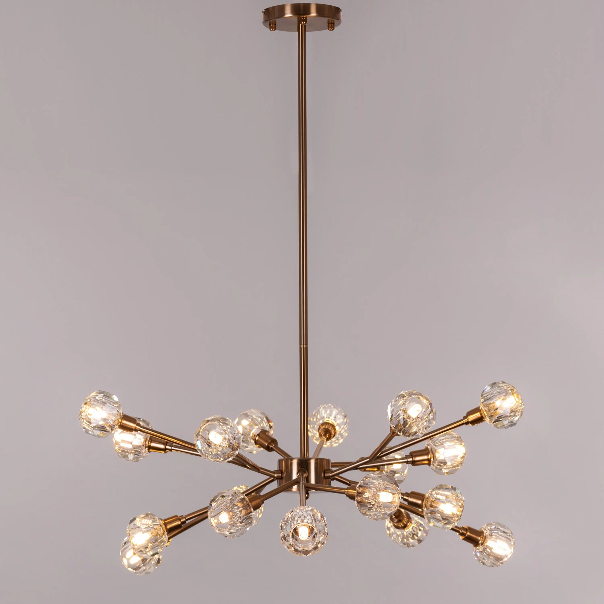 Queen's Necklace medium gold and crystal chandelier illuminating an elegant dining room with its warm, sparkling glow