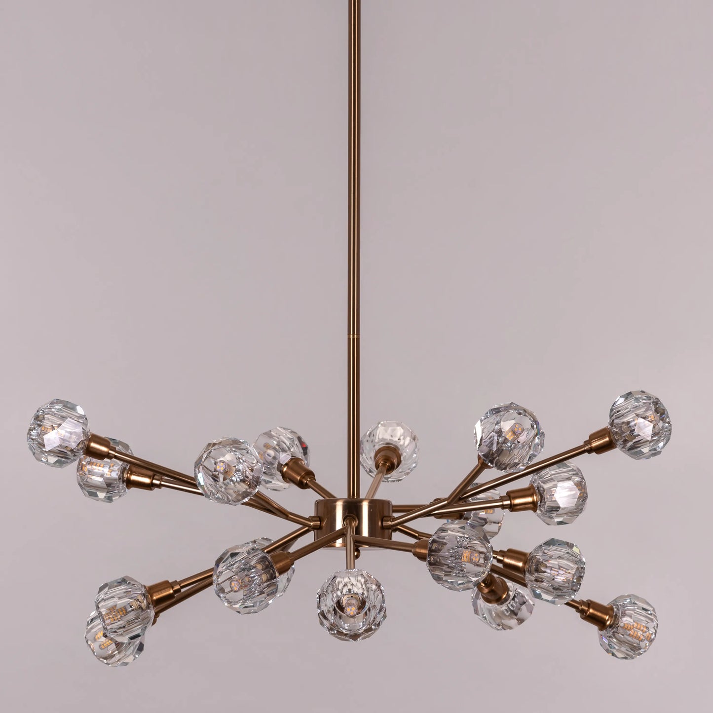 Queen's Necklace medium gold and crystal chandelier illuminating an elegant dining room with its warm, sparkling glow
